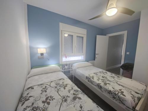 2 camas en una habitación con paredes azules en Atico Gran Boulevard de Albacete - A 5 minutos de la Feria, en Albacete