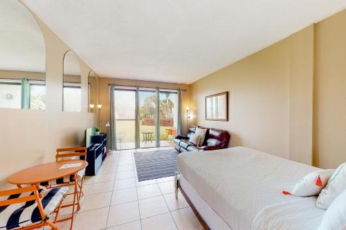 a bedroom with a bed and a table and a couch at Pirates Bay A102 in Fort Walton Beach