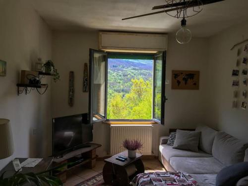 ein Wohnzimmer mit einem Sofa und einem großen Fenster in der Unterkunft Casa dei nonni 
