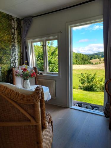 a room with a table and a large window at Älgbergets Bed & Breakfast in Ucklum