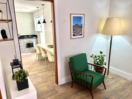 uma sala de estar com uma cadeira verde e uma mesa em Casa Nova - Excelente Localização em Piracicaba