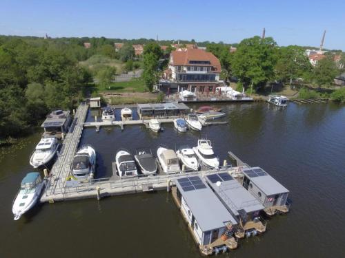 a group of boats docked at a dock in the water at Hausboot Edda in Wildau