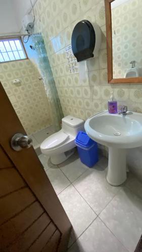 a bathroom with a toilet and a sink at Poseidon Guest House in Iquitos