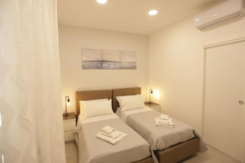 a bedroom with two beds with towels on them at Santa Chiara Luxury House in Naples