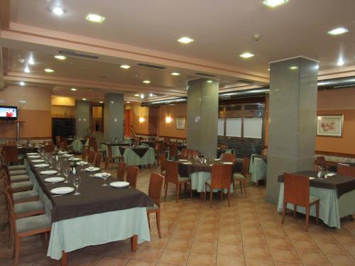 uma sala de jantar com mesas e cadeiras num restaurante em Hotel Virgen del Camino Pontevedra em Pontevedra