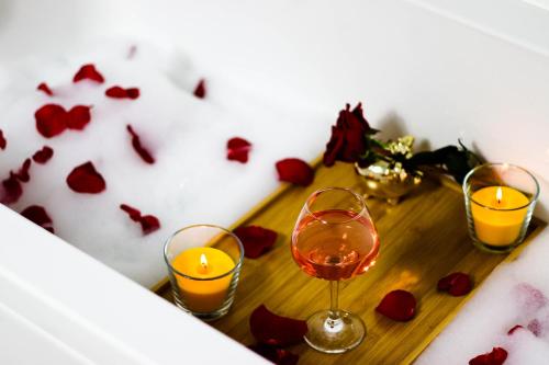 two glasses of wine and candles on a table at Modern & Comfortable Apartament Cismigiu Park - POP3 in Bucharest