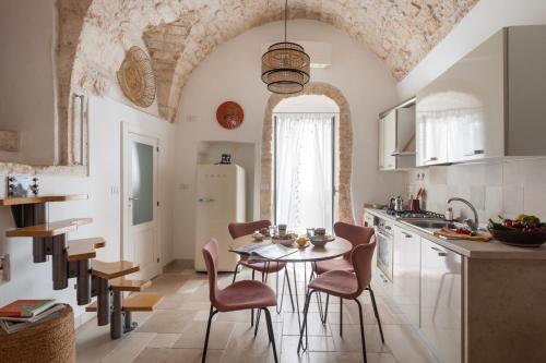 a kitchen with a table and chairs in a room at Casa Antica Pietra Ostuni in Ostuni