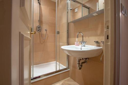La salle de bains est pourvue d'un lavabo et d'une douche. dans l'établissement PRESTIGE Mont Boron -Terrace -Sea View -2BR, à Nice