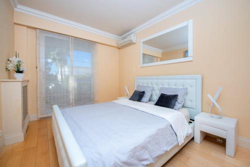 um quarto com uma grande cama branca e uma janela em PRESTIGE Mont Boron -Terrace -Sea View -2BR em Nice