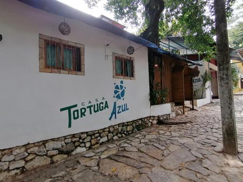 a white building with a sign on the side of it at Casa Tortuga Azul in Palenque