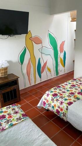 a room with two beds and a tv on a wall at Hotel campestre La Esperanza en Dios in Montenegro