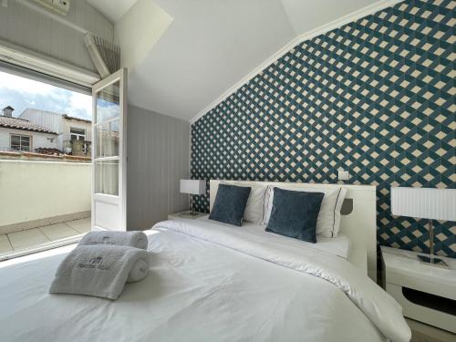 sypialnia z dużym białym łóżkiem i oknem w obiekcie PORTA NOVA Historic Center - Apartments Collection by Perpetual Relax w mieście Braga