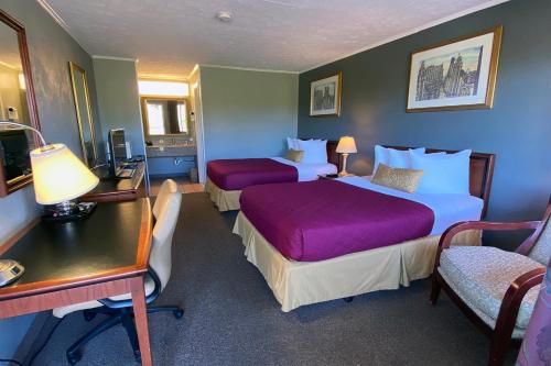 a hotel room with two beds and a desk at Lake Logan Inn in Logan