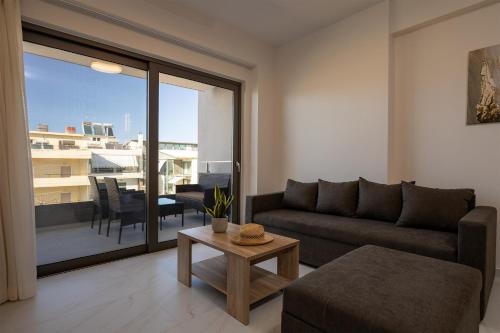 un soggiorno con divano e tavolo di Ruby Luxury Suites a Chania