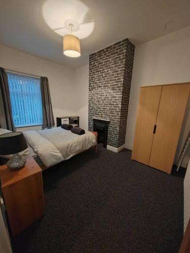a bedroom with a bed and a brick wall at Church View house,2bed,brighouse central location in Brighouse