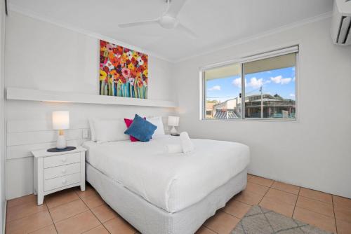 a white bedroom with a bed and a window at Apartment 9T in Lennox Head