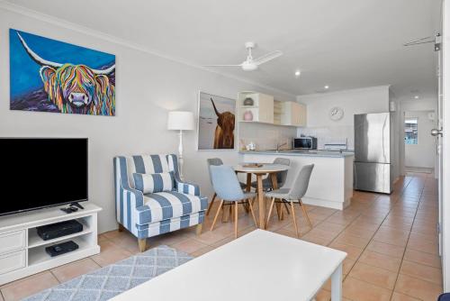 a living room with a television and a dining room at Apartment 9T in Lennox Head