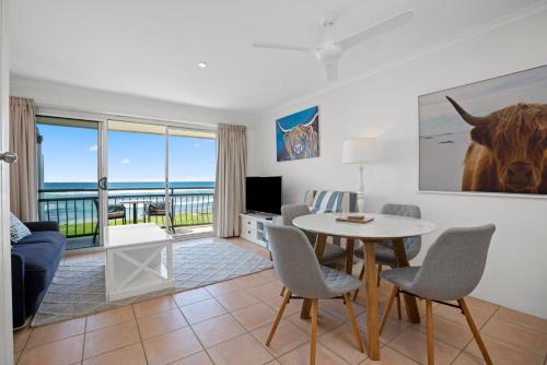 a living room with a couch and a table with chairs at Apartment 9T in Lennox Head