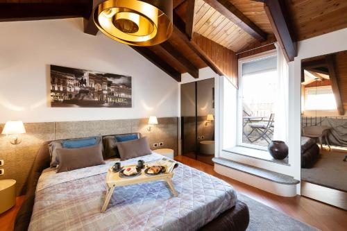 ein Schlafzimmer mit einem großen Bett und einem Tisch darauf in der Unterkunft Casa del Borgo - Esclusiva Suite centro Monza con vista Duomo in Monza