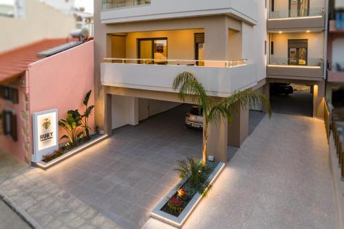 une vue aérienne sur un bâtiment avec un palmier dans l'établissement Ruby Luxury Suites, à La Canée