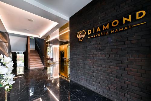 a hotel lobby with a sign on a brick wall at Diamond svečių namai in Kaunas