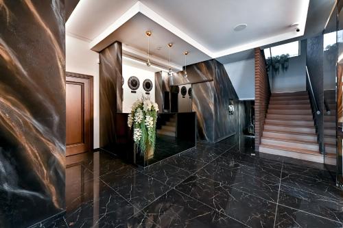 a lobby with a staircase and a vase of flowers at Diamond svečių namai in Kaunas