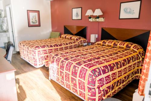 two beds in a hotel room with red walls at Exclusive Quarters in Cleveland
