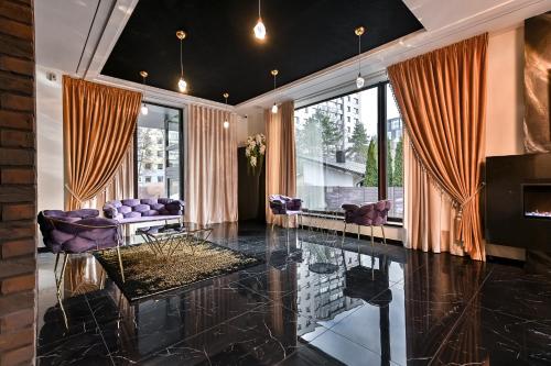a living room with purple chairs and a large window at Diamond svečių namai in Kaunas