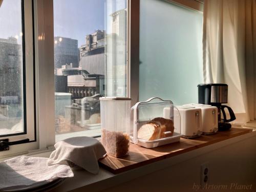 a kitchen counter with a window with bread and appliances at ARA125 in Seoul