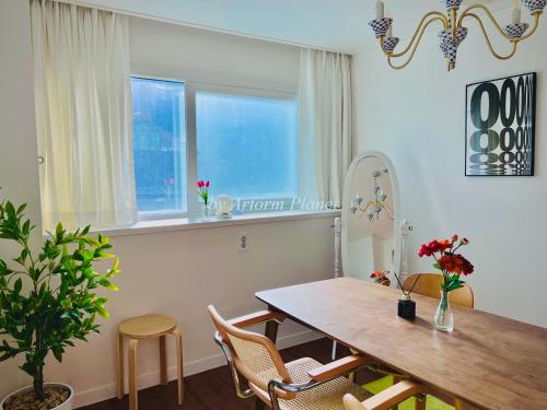 a dining room with a table and chairs and a window at ARA125 in Seoul