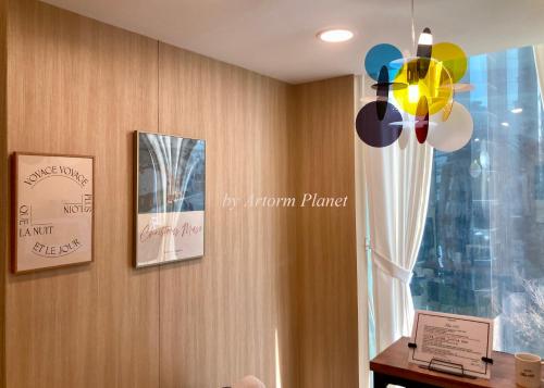 a room with a wall with pictures and a ceiling fan at ARA125 in Seoul