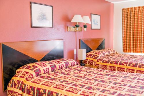 two beds in a hotel room with red walls at Exclusive Quarters in Cleveland