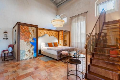 a bedroom with a bed and a staircase with a stair case at Palazzo Maresgallo Suites & SPA in Lecce
