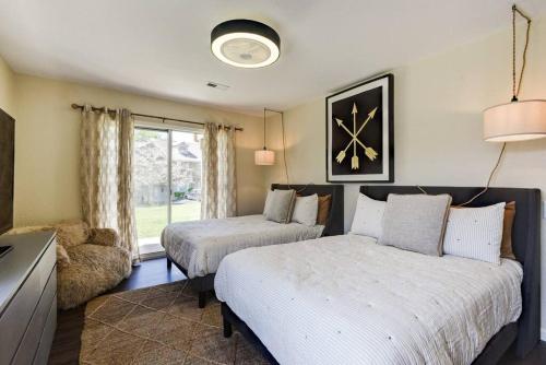 a bedroom with two beds and a clock on the wall at Sparkling Designer 3 bed Suite by Taneycomo in Branson