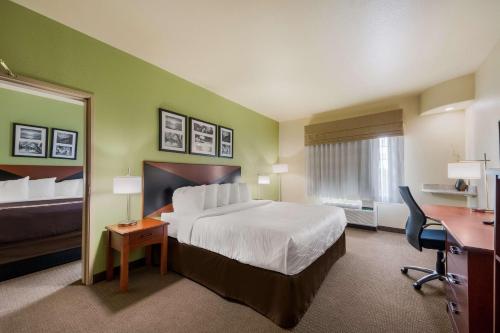 a hotel room with a bed and a desk at SureStay Plus Hotel by Best Western Near SeaWorld San Antonio in San Antonio