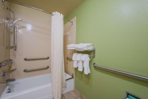 a bathroom with a shower and a bath tub with towels at SureStay Plus Hotel by Best Western Near SeaWorld San Antonio in San Antonio