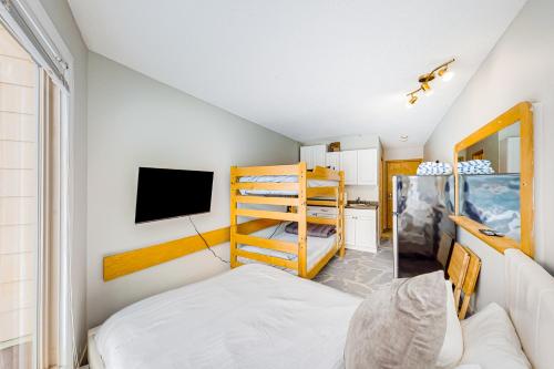 Whitefoot Lodge 314 في منتجع التزلج الأبيض الكبير: غرفة نوم مع سرير بطابقين وتلفزيون