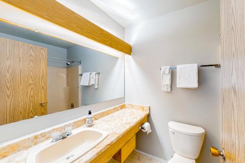 a bathroom with a sink and a toilet and a mirror at Whitefoot Lodge 314 in Big White