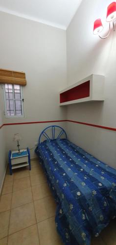 a bedroom with a bed and a table in it at La casita de la San Martín in San Fernando del Valle de Catamarca