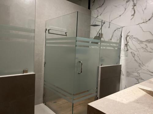 La salle de bains est pourvue d'une douche avec une porte en verre. dans l'établissement Tulum 3 · Acogedor y céntrico depa, à Mazatlán
