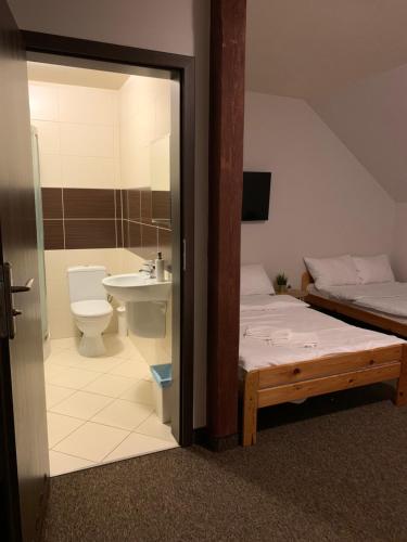 a bathroom with a bed and a toilet and a sink at Victoria in Elblag