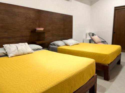 - 2 lits dans une chambre avec des draps jaunes dans l'établissement Tulum 3 · Acogedor y céntrico depa, à Mazatlán