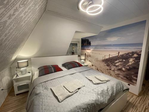 een slaapkamer met een bed en een schilderij van een strand bij Große Ferienwohnung zu vermieten in Lütjenburg