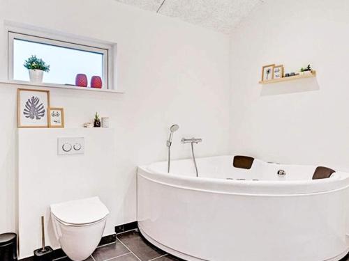 baño blanco con bañera y aseo en Holiday home Vinderup XXIX, en Vinderup