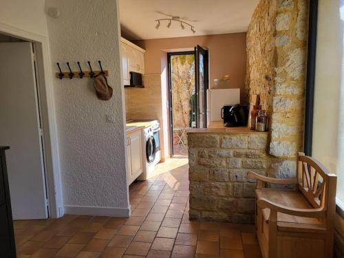 - une cuisine avec un mur en pierre et une cuisinière dans l'établissement Le p'tit nid Bourian, à Concorès