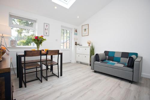 a living room with a couch and a table at The Bearded Goat Den - A rural retreat at this modern holiday cottage in Saint Leonards