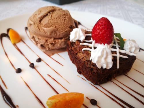 a piece of chocolate cake with ice cream and a strawberry at Hotel Las Lomas in Lima