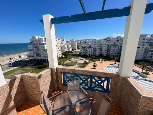 a balcony with a view of the beach and buildings at Appartement City Jardin - Pied sur mer in Martil