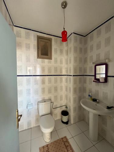 een badkamer met een toilet en een wastafel bij Appartement City Jardin - Pied sur mer in Martil