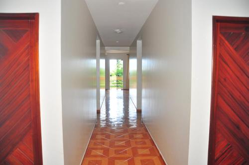a hallway with white walls and red doors at Hotel Litoral in Aracaju